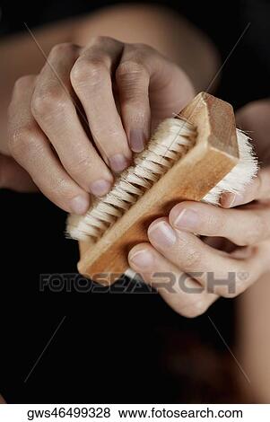 Stock Photo - Close-up of a woman's hand using a brush on her nails. Fotosearch