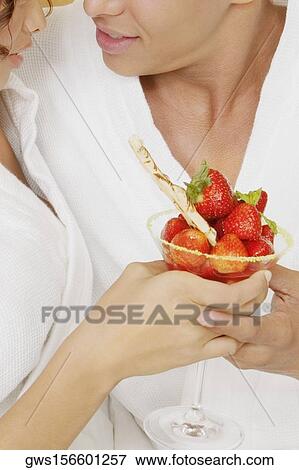 Close-up of a young couple holding a glass of strawberries View Large Photo Image Stock Photo - Close-up of a young couple holding a glass of strawberries. Fotosearch