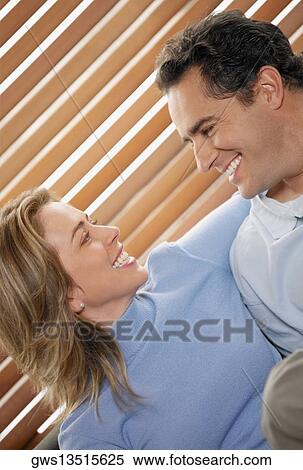 Close-up of a young couple looking at each other and smiling View Large Photo Image Stock Photography - Close-up of a young couple looking at each other and smiling. Fotosearch