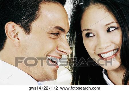 Close-up of a young couple smiling View Large Photo Image Stock Image - Close-up of a young couple smiling. Fotosearch