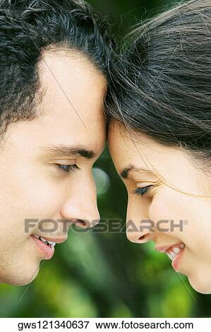 Close-up of a young couple smiling View Large Photo Image Stock Photo - Close-up of a young couple smiling. Fotosearch