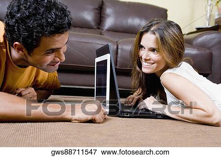 Close-up of a young couple using laptops View Large Photo Image Stock Photo - Close-up of a young couple using laptops. Fotosearch