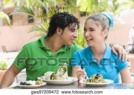 Close-up of a young man and a teenage girl sitting at a table in a restaurant View Large Photo Image Stock Image - Close-up of a young man and a teenage girl sitting at a table in a restaurant. Fotosearch