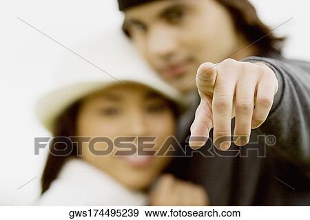 Close-up of a young man and a young woman pointing View Large Photo Image Stock Photo - Close-up of a young man and a young woman pointing. Fotosearch