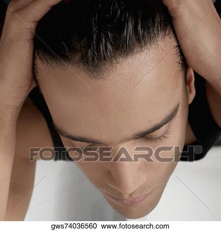 Stock Image - Close-up of a young man applying hair gel. Fotosearch