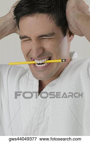 Close-up of a young man biting a pencil with his head in his hands View Large Photo Image Stock Photo - Close-up of a young man biting a pencil with his head in his hands. Fotosearch