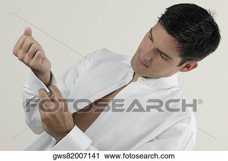 Close-up of a young man buttoning his cuff View Large Photo Image Stock Image - Close-up of a young man buttoning his cuff. Fotosearch