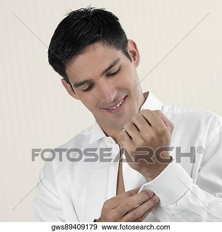 Close-up of a young man buttoning his cuff View Large Photo Image Stock Photo - Close-up of a young man buttoning his cuff. Fotosearch