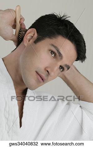 Close-up of a young man combing his hair View Large Photo Image Stock Image - Close-up of a young man combing his hair. Fotosearch