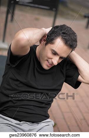 Close-up of a young man doing sit-ups with his hands behind his head View Large Photo Image Stock Photograph - Close-up of a young man doing sit-ups with his hands behind his head. Fotosearch