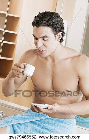 Stock Image - Close-up of a young man drinking a cup of tea. Fotosearch