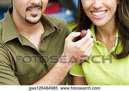 Close-up of a young man feeding a strawberry to a young woman View Large Photo Image Stock Photography - Close-up of a young man feeding a strawberry to a young woman. Fotosearch