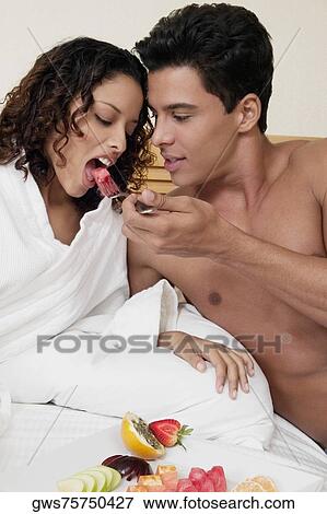 Close-up of a young man feeding watermelon to a teenage girl View Large Photo Image Stock Photo - Close-up of a young man feeding watermelon to a teenage girl . Fotosearch