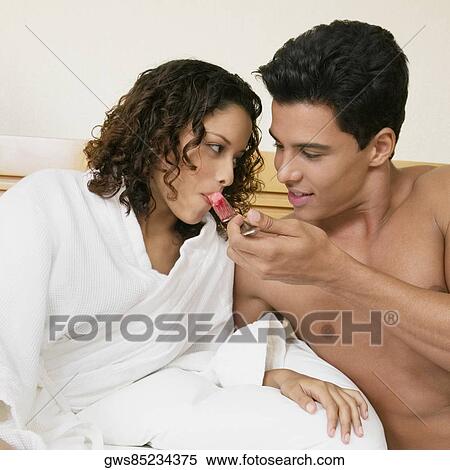 Stock Photography - Close-up of a young man feeding watermelon to a teenage girl . Fotosearch