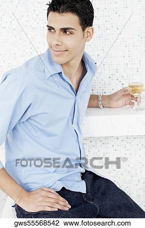 Close-up of a young man holding a glass of wine View Large Photo Image Stock Image - Close-up of a young man holding a glass of wine. Fotosearch