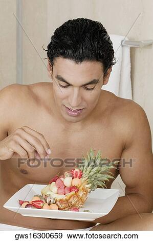 Close-up of a young man holding a plate of fruit View Large Photo Image Stock Photo - Close-up of a young man holding a plate of fruit. Fotosearch