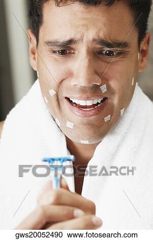 Close-up of a young man holding a razor View Large Photo Image Stock Image - Close-up of a young man holding a razor. Fotosearch