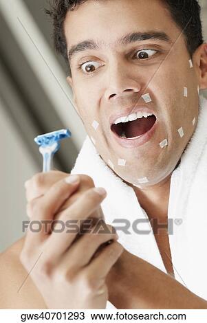 Stock Image - Close-up of a young man holding a razor. Fotosearch