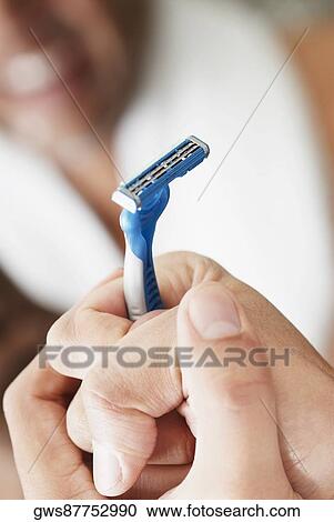 Close-up of a young man holding a razor View Large Photo Image Stock Image - Close-up of a young man holding a razor. Fotosearch