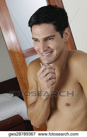 Close-up of a young man holding a mobile phone View Large Photo Image Stock Photo - Close-up of a young man holding a mobile phone. Fotosearch