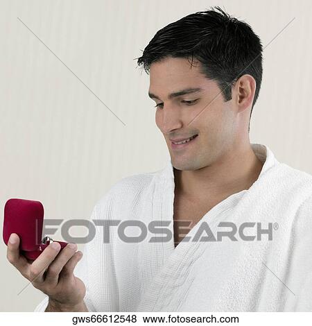 Stock Photo - Close-up of a young man holding a jewelry box. Fotosearch