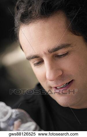 Close-up of a young man holding a bottle of water View Large Photo Image Stock Photography - Close-up of a young man holding a bottle of water. Fotosearch