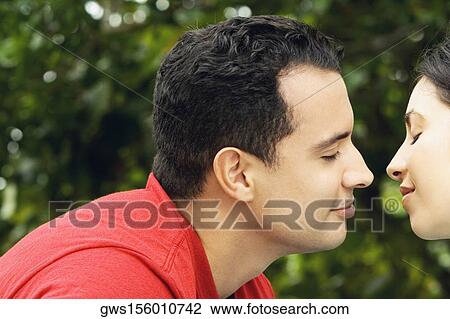 Stock Image - Close-up of a young man kissing a young woman. Fotosearch