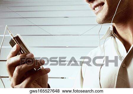 Stock Photo - Close-up of a young man listening to music. Fotosearch