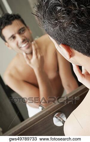 Close-up of a young man looking into a mirror and smiling View Large Photo Image Stock Image - Close-up of a young man looking into a mirror and smiling. Fotosearch