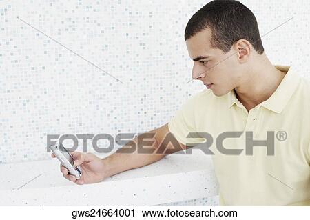 Close-up of a young man operating a mobile phone View Large Photo Image Stock Image - Close-up of a young man operating a mobile phone. Fotosearch