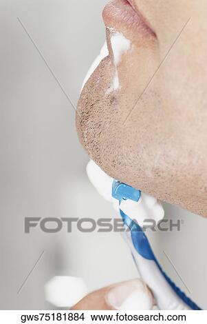 Close-up of a young man shaving View Large Photo Image Picture - Close-up of a young man shaving. Fotosearch