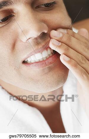 Close-up of a young man showing his teeth View Large Photo Image Stock Photography - Close-up of a young man showing his teeth. Fotosearch