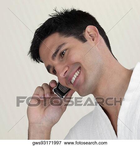 Close-up of a young man talking on a mobile phone View Large Photo Image Stock Photo - Close-up of a young man talking on a mobile phone. Fotosearch