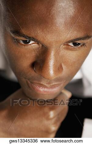 Close-up of a young man thinking View Large Photo Image Stock Photograph - Close-up of a young man thinking. Fotosearch