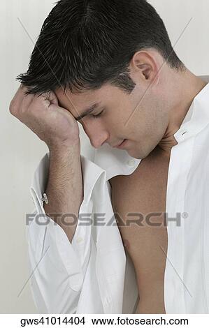 Close-up of a young man thinking with his hand on his forehead View Large Photo Image Picture - Close-up of a young man thinking with his hand on his forehead. Fotosearch
