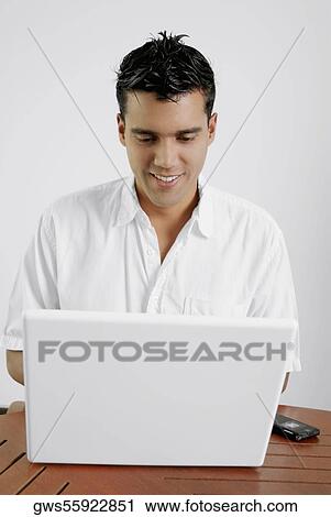 Close-up of a young man using a laptop View Large Photo Image Stock Image - Close-up of a young man using a laptop. Fotosearch