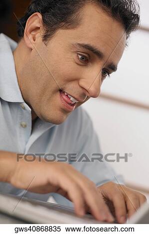 Close-up of a young man using a laptop View Large Photo Image Stock Photography - Close-up of a young man using a laptop. Fotosearch