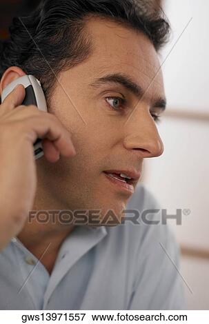 Stock Photo - Close-up of a young man using a mobile phone. Fotosearch
