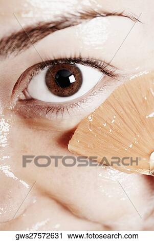 Close-up of a young woman applying a facial mask View Large Photo Image Stock Image - Close-up of a young woman applying a facial mask. Fotosearch