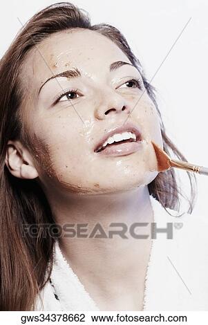 Close-up of a young woman applying a facial mask View Large Photo Image Stock Image - Close-up of a young woman applying a facial mask. Fotosearch