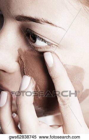 Close-up of a young woman applying a facial mask View Large Photo Image Stock Photography - Close-up of a young woman applying a facial mask. Fotosearch