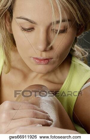Stock Photograph - Close-up of a young woman applying hair removing cream on her leg. Fotosearch