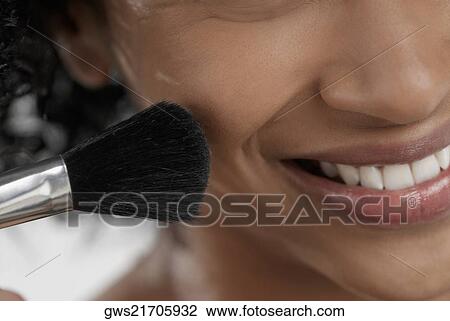 Close-up of a young woman applying blush with a brush View Large Photo Image Stock Image - Close-up of a young woman applying blush with a brush. Fotosearch