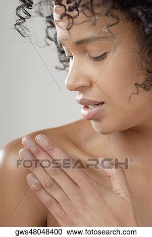 Close-up of a young woman applying moisturizer on her shoulder View Large Photo Image Stock Image - Close-up of a young woman applying moisturizer on her shoulder. Fotosearch