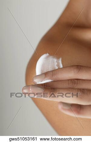 Close-up of a young woman applying moisturizer on her shoulder View Large Photo Image Stock Image - Close-up of a young woman applying moisturizer on her shoulder. Fotosearch