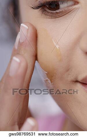 Close-up of a young woman applying honey on her cheek View Large Photo Image Stock Image - Close-up of a young woman applying honey on her cheek. Fotosearch
