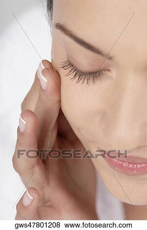 Close-up of a young woman applying moisturizer on her cheeks View Large Photo Image Stock Photo - Close-up of a young woman applying moisturizer on her cheeks. Fotosearch
