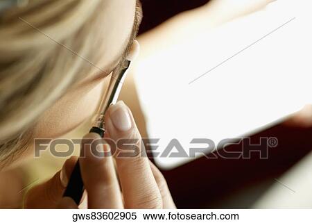 Close-up of a young woman applying eyeshadow View Large Photo Image Stock Photography - Close-up of a young woman applying eyeshadow. Fotosearch