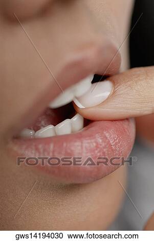 Close-up of a young woman biting her finger View Large Photo Image Stock Image - Close-up of a young woman biting her finger. Fotosearch
