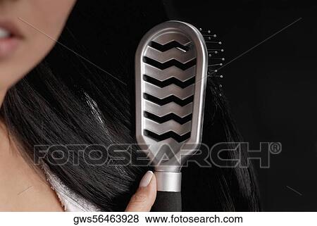 Close-up of a young woman brushing her hair View Large Photo Image Stock Photo - Close-up of a young woman brushing her hair. Fotosearch